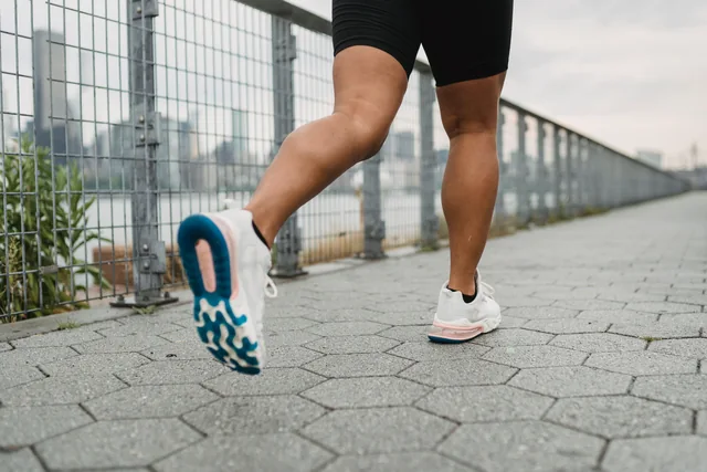 Piernas y zapatillas de una persona corriendo al aire libre